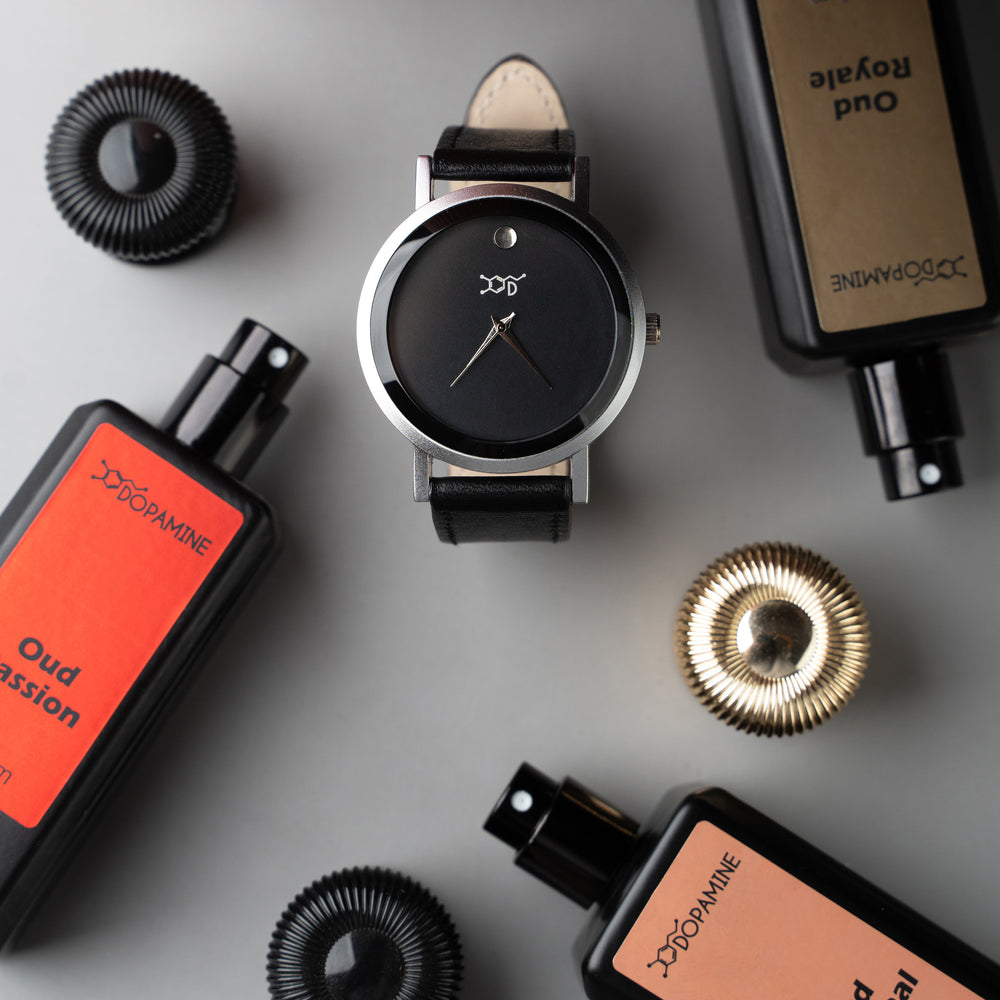 Dopamine watch surrounded by Oud Parfum bottles