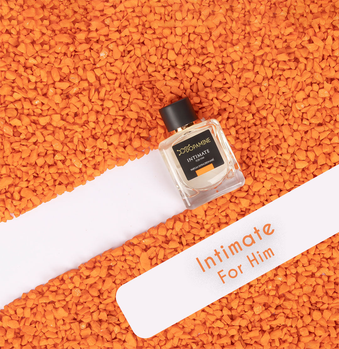 Image of Intimate Perfume for Man sprayed over orange colored mini stones